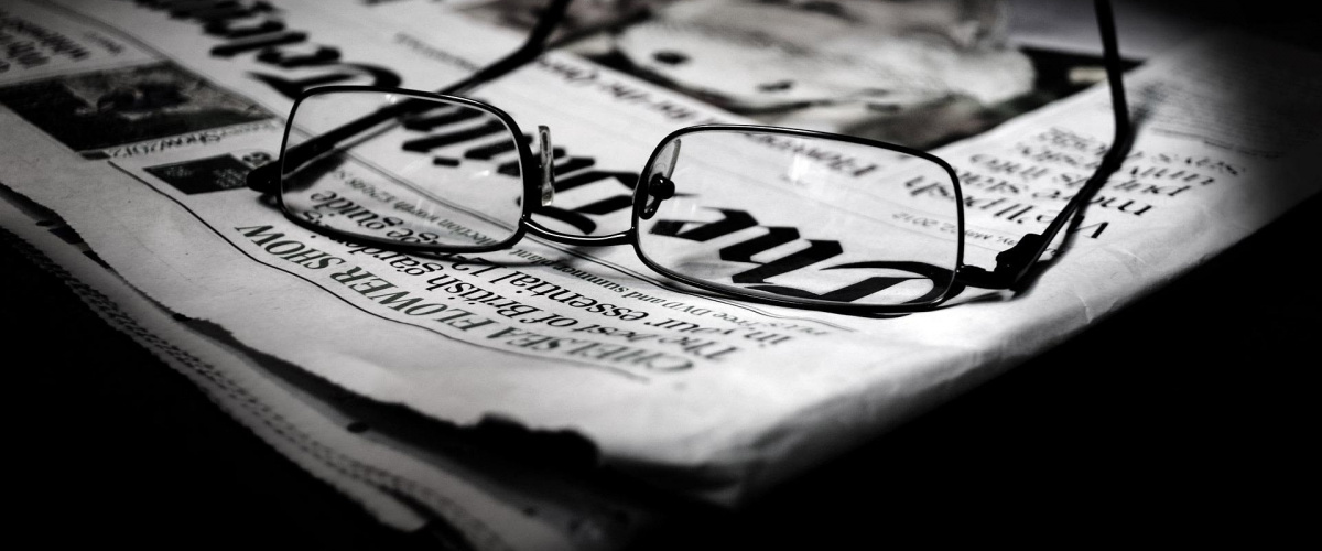 okuliare položené na novinách